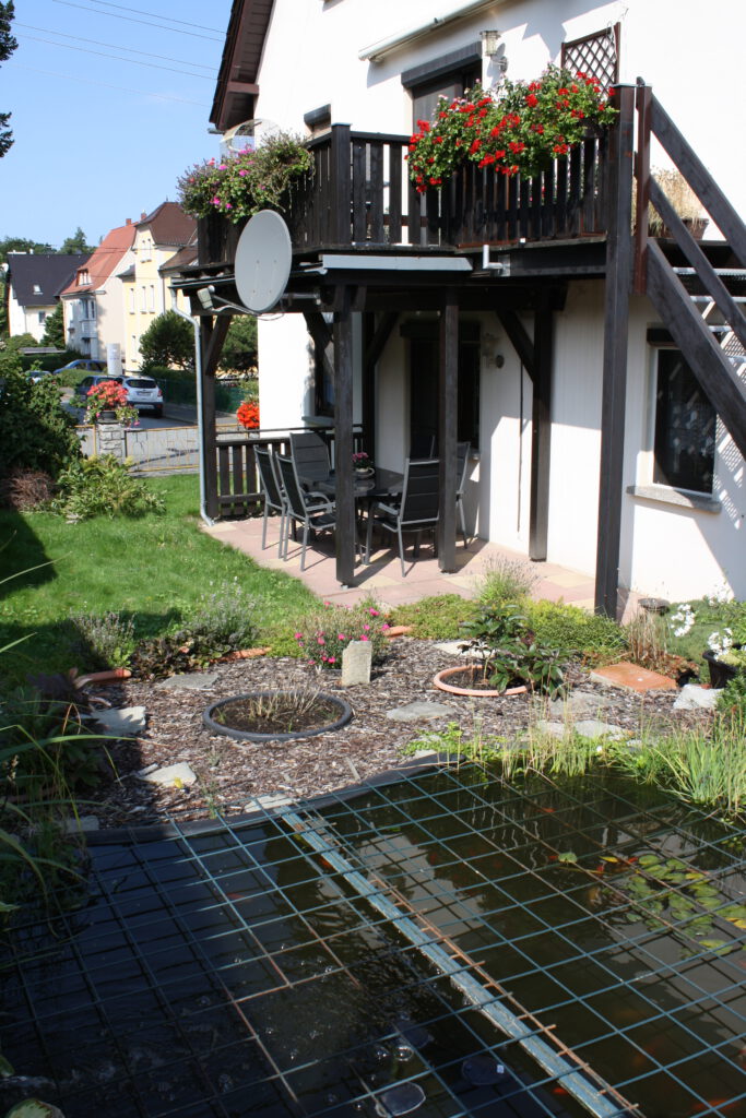 Terrasse mit Wiese und Fischteich